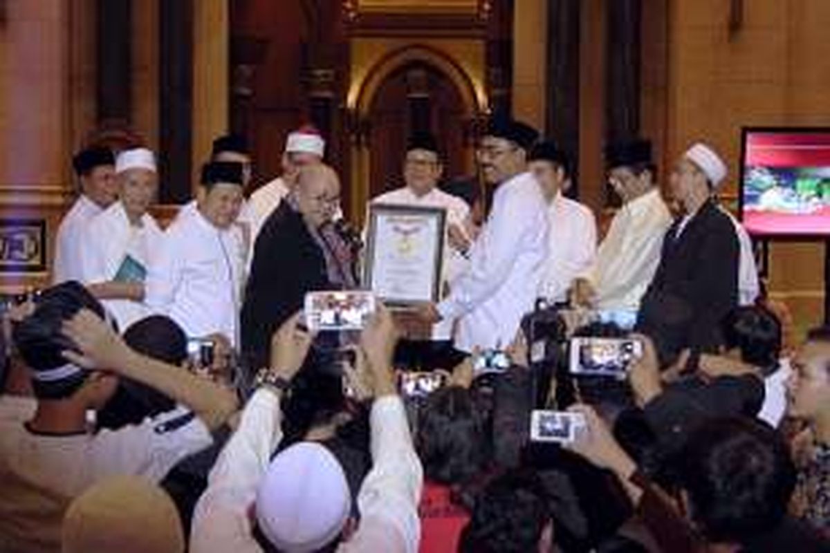 Pendiri Museum Rekor Indonesia (Muri) Jaya Suprana (tengah berbaju hitam), Selasa (21/6/2016), menyerahkan sertifikat rekor khataman serentak selama 24 jam kepada Koordinator Nasional Gerakan Nusantara Mengaji.