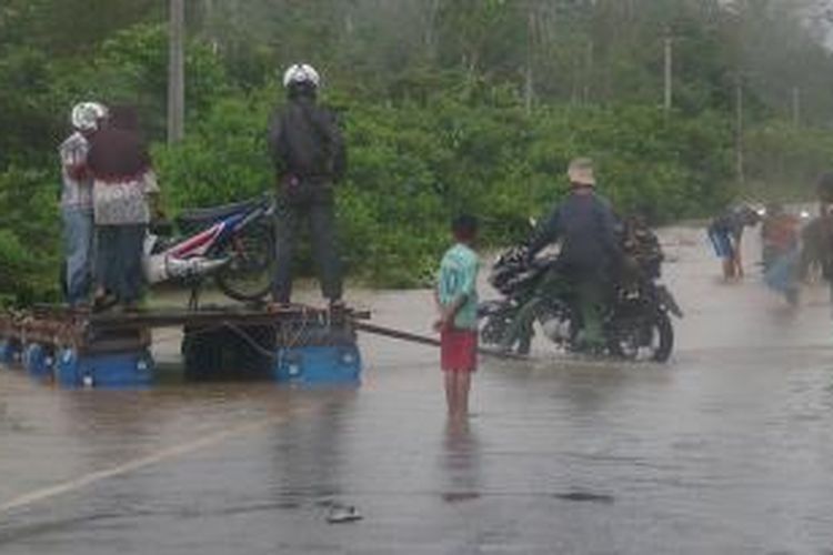 Akibat banjir yang menggenangi Jalan Ateung Teupat, Kabupaten Aceh Barat, warga terpaksa menggunakan jasa rakit penyeberangan,