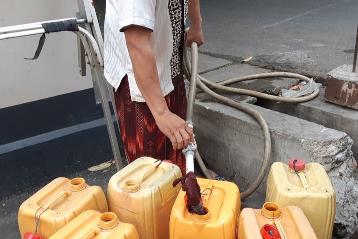 Saiful Anwar (40) sedang mengisi air PAM dalam dirigen sebab kelangkaan air bersih yang sudah melanda warga RW 09, Kelurahan Pegadungan, Kalideres, Jakarta Barat, Kamis (19/9/2019)