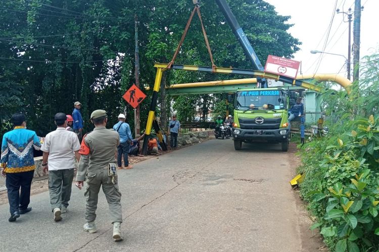 Tuk crane tersangkut di portal pembatas ketinggian di Jalan Krukut, Limo, Depok pada Kamis (13/10/2022). (Dokumen: Satpol PP Depok).