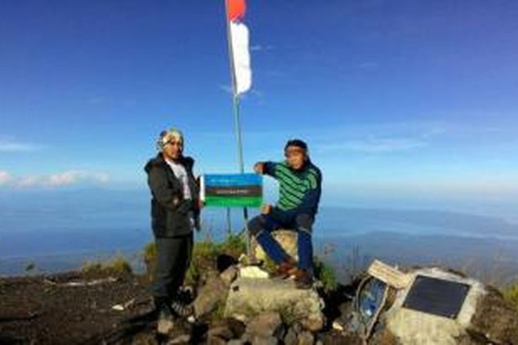 Editor Teks Firman Firdaus dan Kartografer Sony Warsono mengibarkan bendera NatGeo Society yang menginspirasi penjelajahan di bumi di Puncak Tambora. 