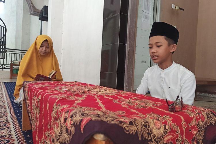 Najih Maulana (peci), mengucapkan hafalan ayat Alquran dihadapan guru pembombing SDI Lukman Al-hakim Trenggalek Jawa Timur, Kamis (02/07/2020).