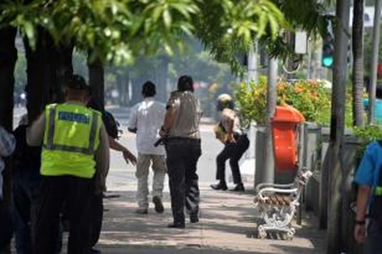 Polisi mengejar terduga pelaku yang diperkirakan bersembunyi di sebuah kafe setelah ledakan menghantam kawasan Jalan MH Thamrin, Jakarta Pusat, 14 Januari 2016. Serangkaian ledakan menewaskan sejumlah orang, terjadi baku tembak antara polisi dan beberapa orang yang diduga pelaku.