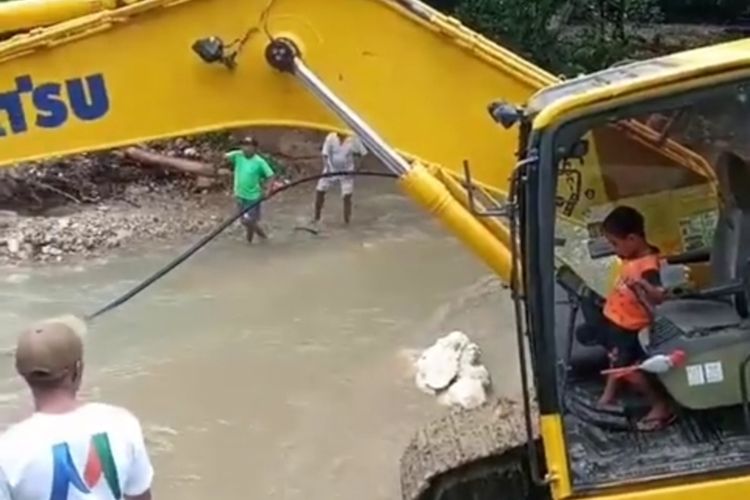 Theo Paays (5) seorang bocah asal Desa Amahusu, Kecamatan, Leitimir Selatan mengoperasikan sendiri eskavator untuk menormalisasi sungai di desa tersebut, Minggu (4/10/2020).