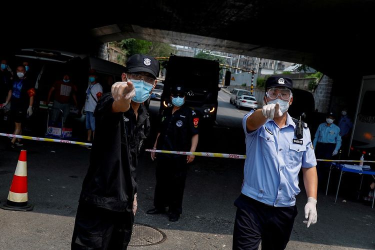 Polisi dan anggota keamanan berusaha mencegah fotografer mengambil foto di pembatas yang mengelilingi perumahan penduduk, di dekat pasar Xinfadi, yang telah diberlakukan lockdown setelah penyebaran baru penyakit virus korona (COVID-19) di Beijing, China, Sabtu (20/6/2020).