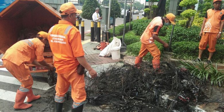 Pasukan oranye atau petugas PPSU Kelurahan Kuningan Barat menemukan gulungan kulit kabel, di gorong-gorong Jalan Gatot Subroto, Jakarta Selatan. 