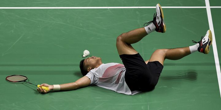 Aksi pebulu tangkis tunggal putra Indonesia Anthony Sinisuka Ginting menjatuhkan diri ke lapangan pertandingan usai menundukkan lawannya pebulu tangkis Jepang Kento Momota pada babak kedua nomor perorangan Asian Games 2018 di Istora Senayan, Jakarta, Sabtu (25/8/2018). - INASGOC