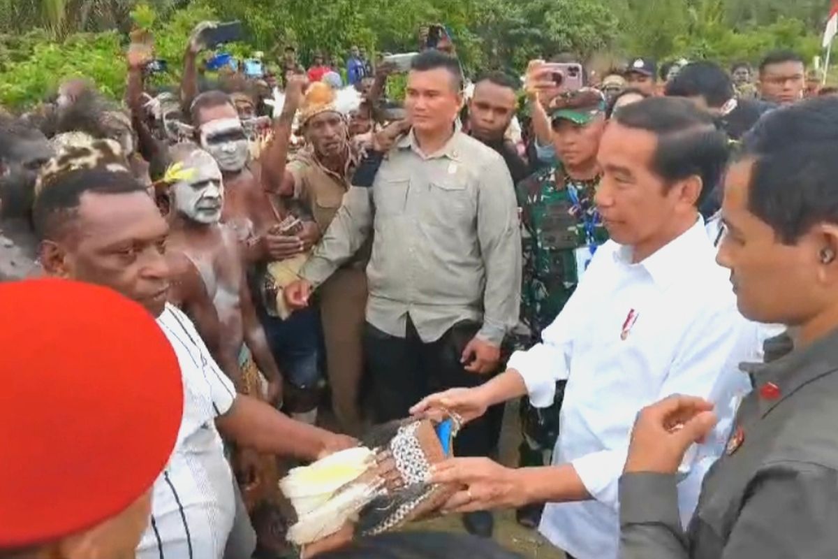 Presiden Joko Widodo saat menerima tas noken dari warga Asmat di kawasan Bandara Ewer, Kabupaten Asmat, Papua Selatan pada Kamis (6/7/2023).
