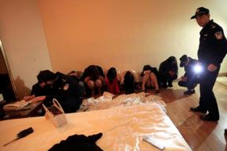 Polisi menahan sejumlah PSK dan pelanggan mereka dalam sebuah operasi besar-besaran memberantas industri seks ilegal di kota Dongguang, China pada 9 Februari 2014. Akibat maraknya industri seks ilegal ini, pemerintah China mencopot kepala kepolisian kota Dongguan.