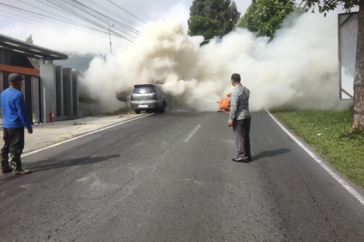 Petugas memadamkan api yang membakar Grand Livina di Jalan Raya Salatiga-Kopeng, Jumat (27/6/2025) 