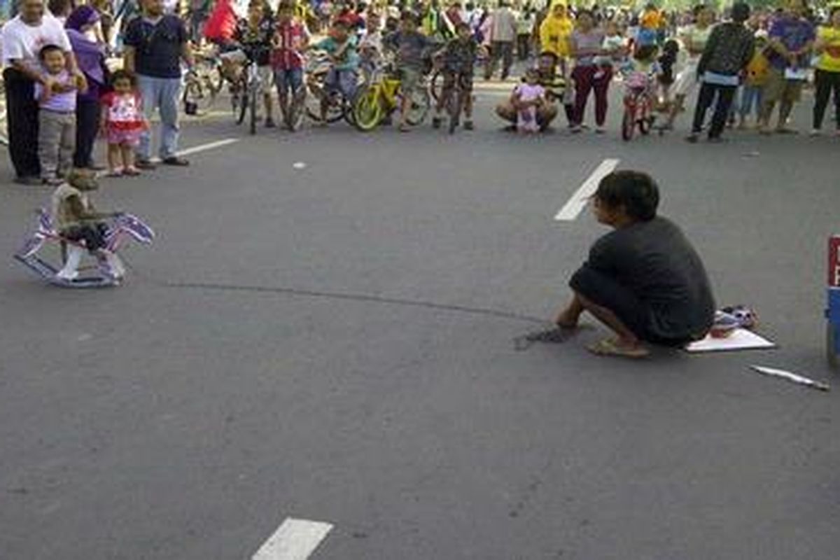 Atraksi topeng monyet saat hari bebas kendarabn bermotor di salah satu jalan di Semarang, Minggu (17/3/2013).