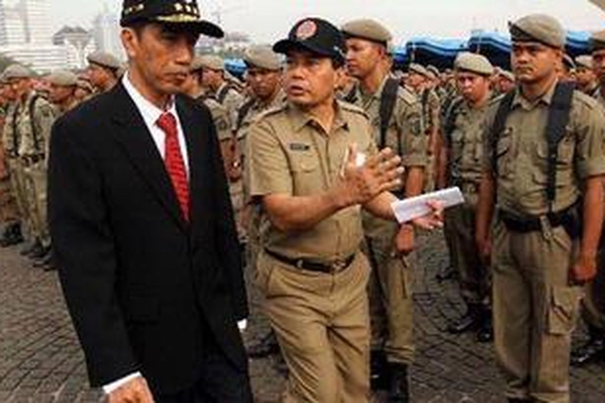 Gubernur DKI Jakarta, Joko Widodo (kiri), melakukan peninjauan kesiapan Satpol PP melakukan saat apel kesiagaan banjir di lapangan Monas Jakarta Pusat, Selasa (6/11/2012). Apel ini dilakukan untuk mengetahui kesiapan menghadapi banjir pada musim hujan tahun ini. 