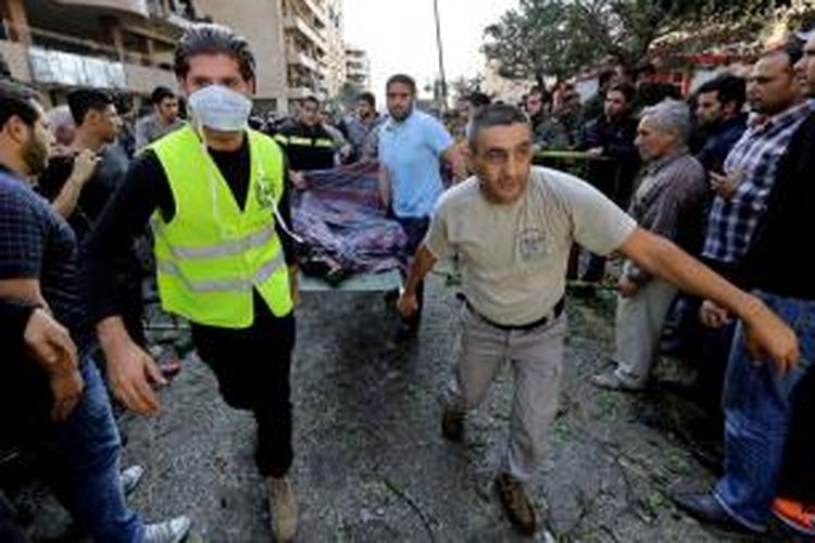Tim penyelamat Lebanon membawa jasad salah seorang korban tewas bom di dekat kedutaan besar Iran di Beirut, Lebanon, Selasa (19/11/2013). Insiden itu menewaskan 22 orang dan melukai 146 orang lainnya.