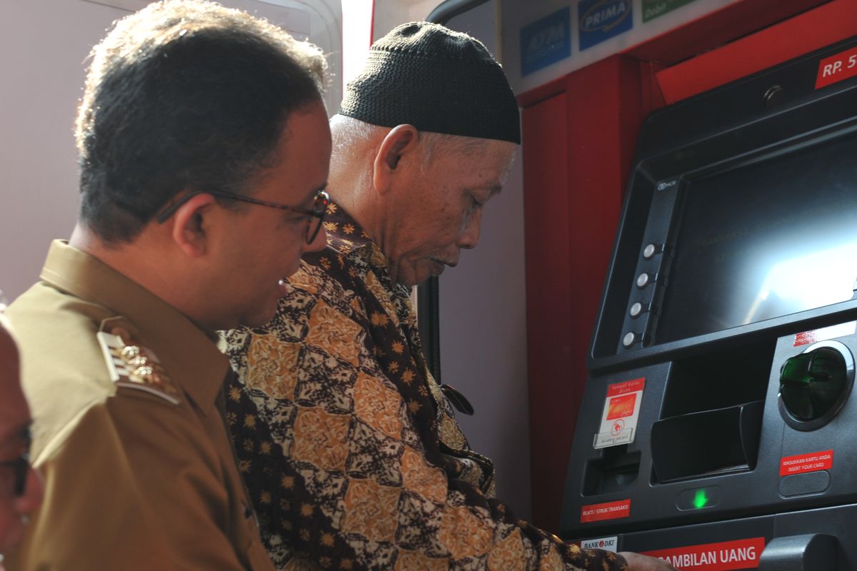 Gubernur DKI Jakarta Anies Baswedan sedang melihat lansia menggunakan Kartu Lansia Jakarta (KLJ).