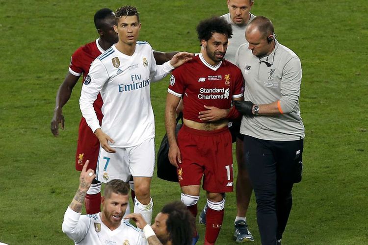 Pemain Real Madrid Cristiano Ronaldo (kiri) berjalan mendampingi pemain Liverpool Mohamed Salah yang mengalami cedera bahu saat laga final Liga Champions 2018 di Stadion NSK Olimpiyskiy di Kiev, Ukraina, Sabtu (26/5/2018) waktu setempat. Real Madrid meraih gelar juara Liga Champions 2018 seusai menang 3-1 atas Liverpool.