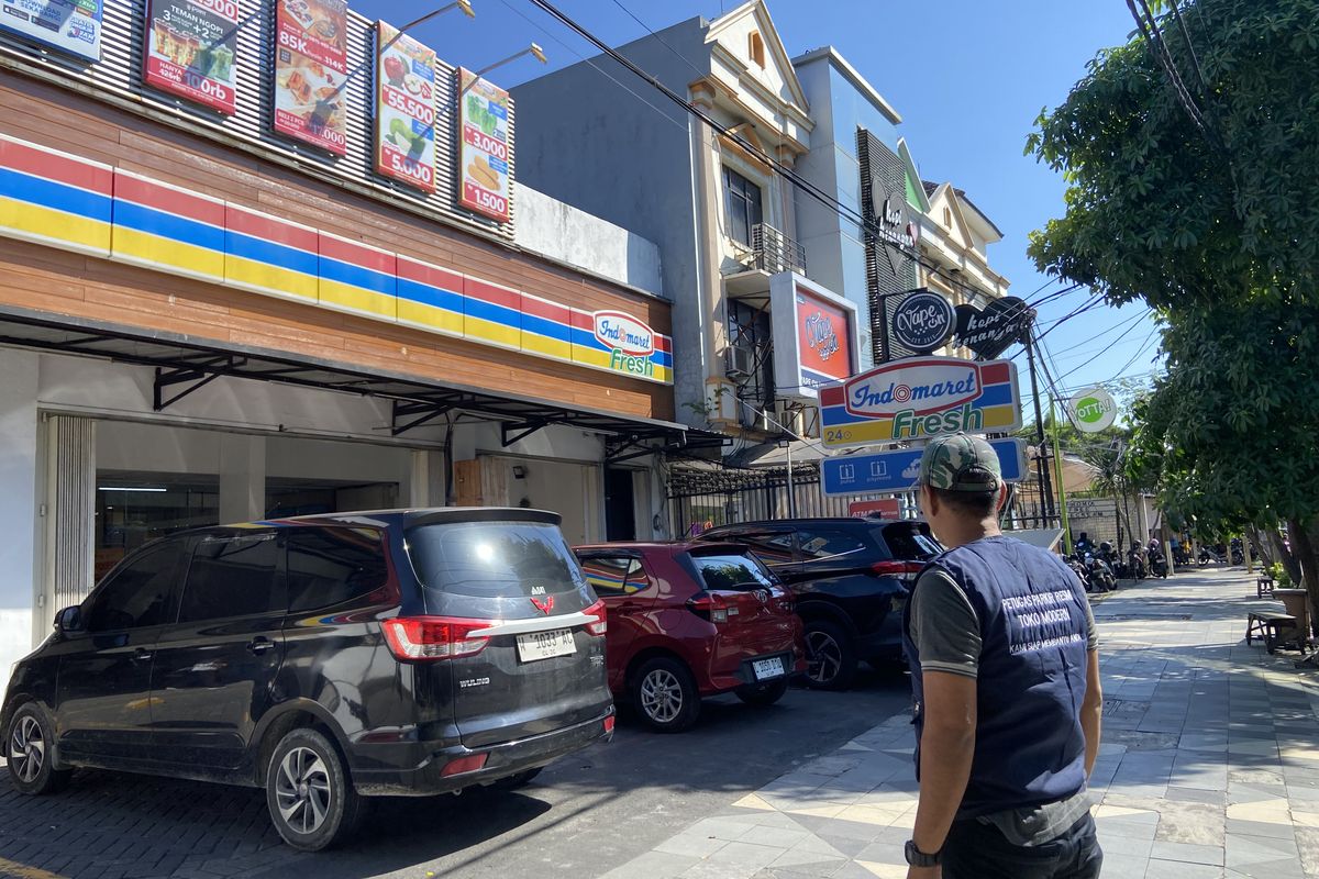 Jukir resmi supermarket di Jalan Dharmahusada Surabaya, Aghofur Qhuzaini (37) saat menertibkan kendaraan, Rabu (11/6/2025).
