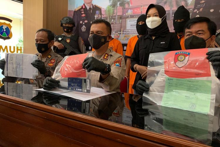 BARANG BUKTI—Kapolres Madiun Kota, AKBP Dewa Putu Eka Darmawan menunjukkan barang bukti lembaran transfer uang dari korban kepada tersangka dengan total nilai sebesar Rp 1.035.000.000 di Mapolres Madiun Kota, Senin (29/11/2021).