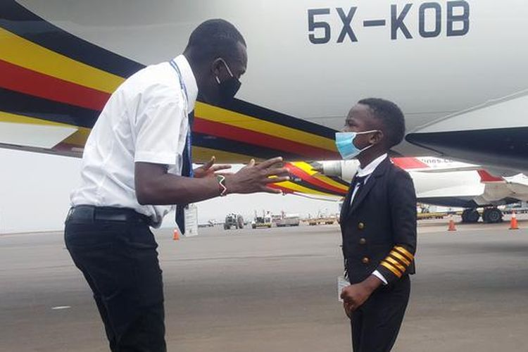 Kapten Graham Shema mendengarkan penjelasan instruktur penerbangan Simon Wadagu Bruno, tentang fungsi beberapa bagian pesawat Bombardier CRJ900 di Bandara Internasional Entebbe, Uganda.