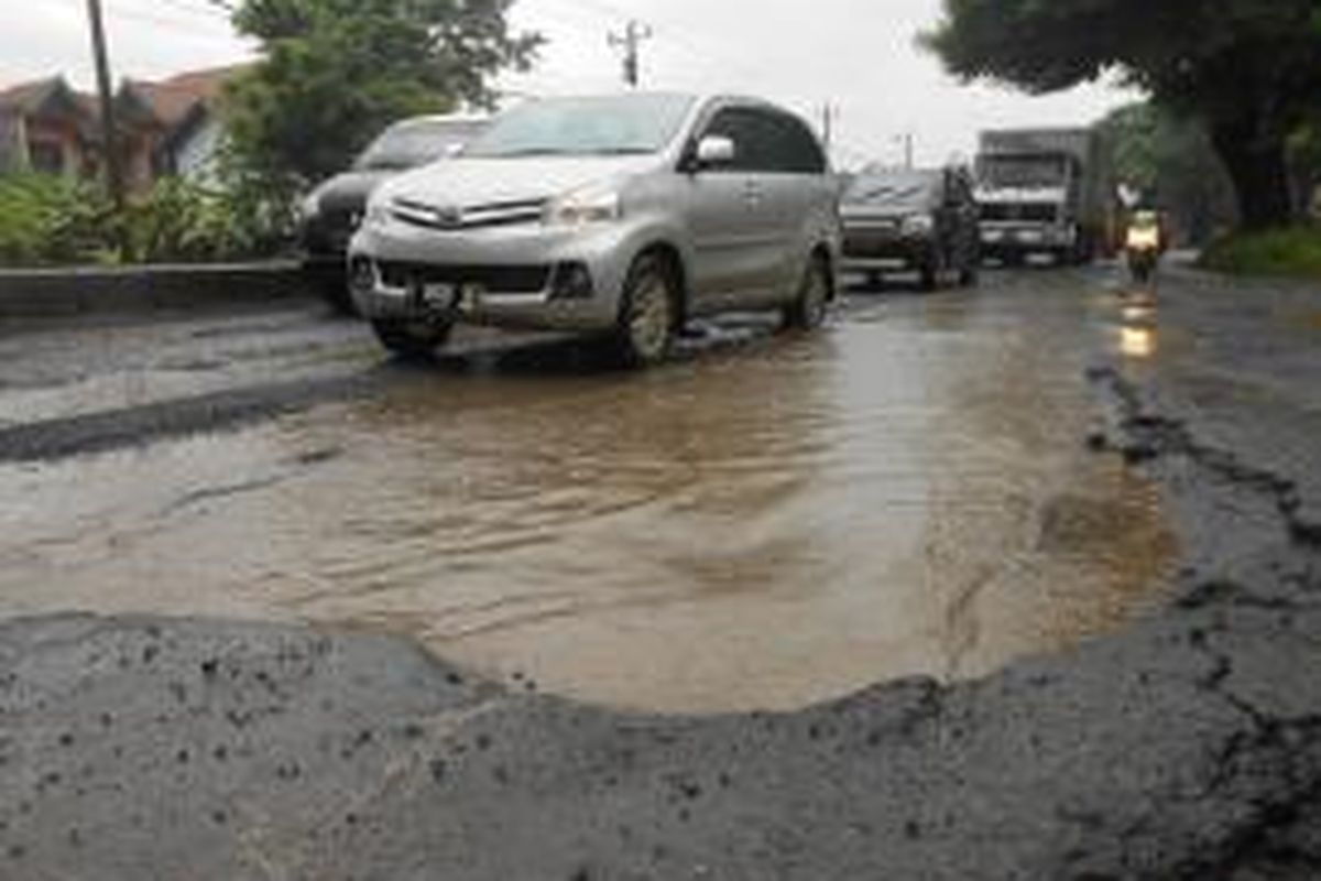 Para pengendara kendaraan bermotor berusaha menghindari jalan yang berlubang  di jalan Pantura , tepatnya di Desa Katonsari Demak, Jawa Tengah. Gambar diambil pada Senin (3/2/2014)