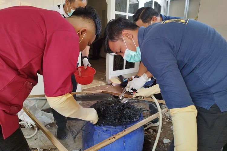 Tim forensik menyaring gumpalan lumpur untuk mencari sisa janin di tempat kejadian perkara (TKP) klinik aborsi ilegal di Jalan Mirah Delima IV No 14, Kemayoran, Jakarta Pusat, Selasa (4/7/2023). (KOMPAS.com/XENA OLIVIA)