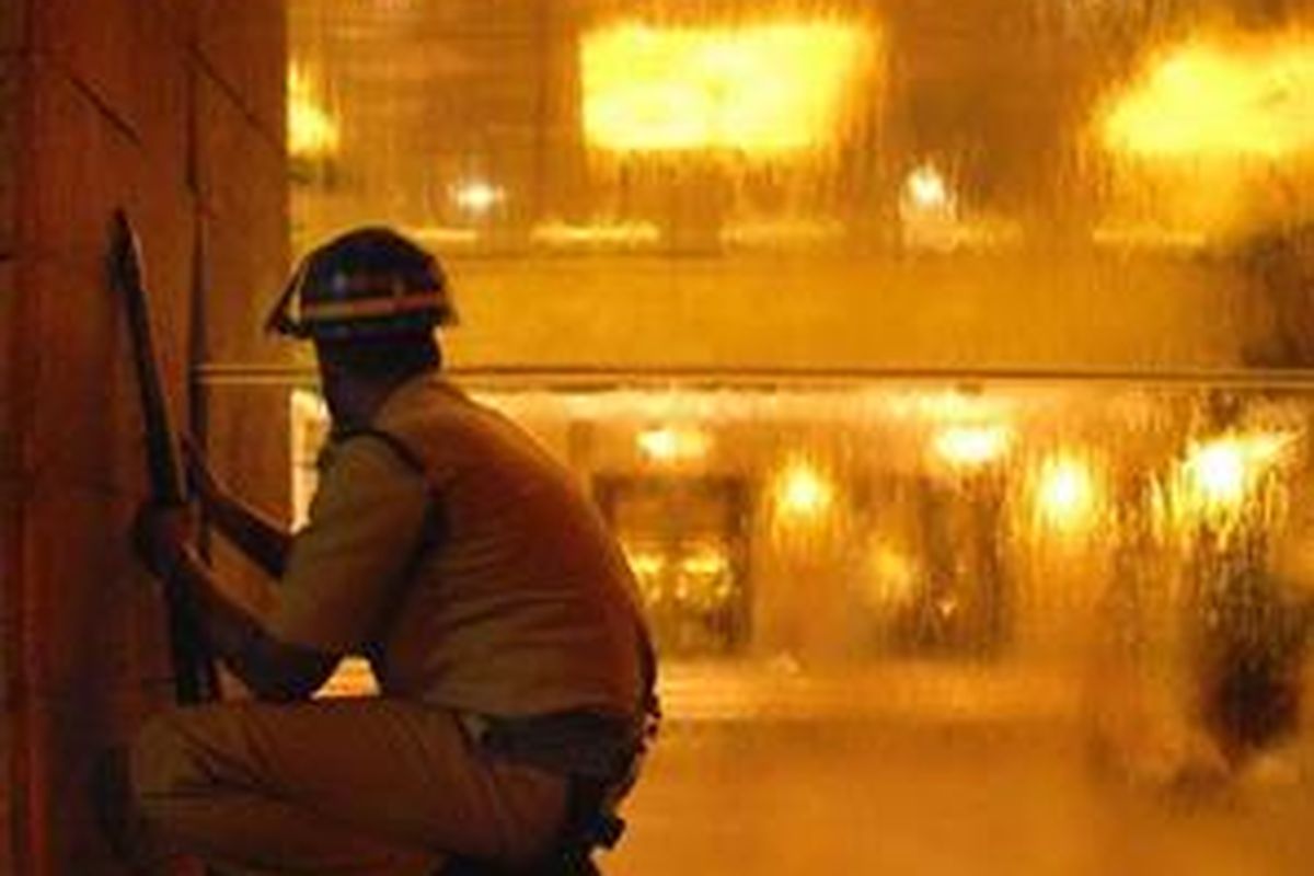 Seorang polisi mengintai hotel Taj Mahal yang sedang diserang gerombolan bersenjata 