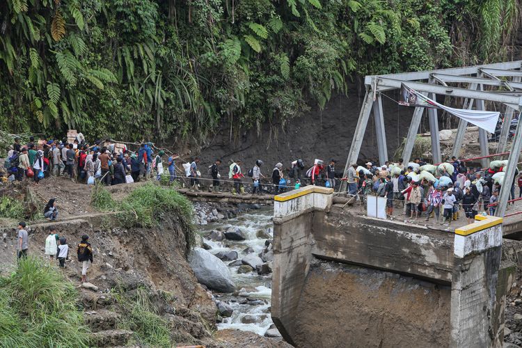 BANJIR SUMATERA: Warga menyeberang sungai dengan jembatan darurat di wilayah Tenge Besi, Kecamatan Pintu Rime Gayo, Kabupaten Bener Meriah, Aceh, Sabtu (20/12/2025). Akses warga pejalan kaki masih harus melintasi jembatan darurat dari batang kayu dan kendaraan roda dua harus menyeberangi arus sungai saat debit air surut, sementara roda empat tidak dapat melintas, akibat jalan dan jembatan penghubung antara Bener Meriah menuju Takengon, Kabupaten Aceh Tengah putus diterjang banjir bandang pada Rabu (26/11/2025).