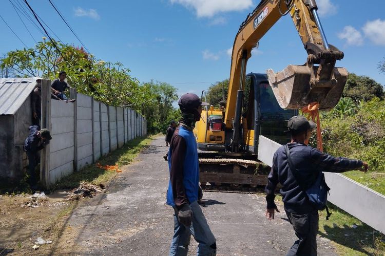 Proses pembongkaran dan penggeseran tembok pembatas GWK. 