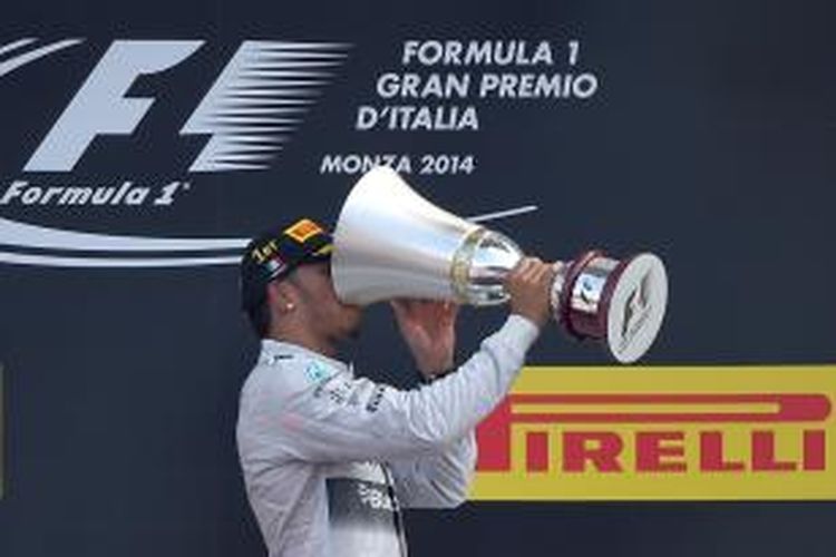 Pebalap Mercedes asal Inggris, Lewis Hamilton, meminum champagne dari trofi juara GP Italia di atas podium Sirkuit Monza, Minggu (7/9/2014). Hamilton finis pertama diikuti Nico Rosberg dan Felipe Massa.