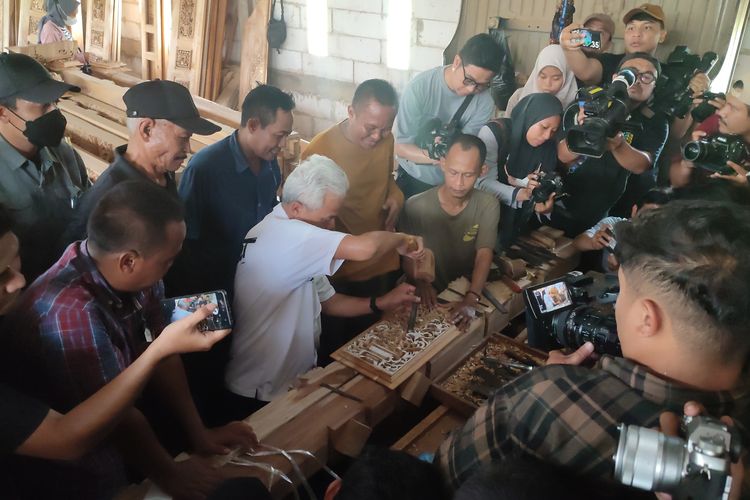 Calon presiden nomor urut 3, Ganjar Pranowo, tengah mengukir gebyok ketika berkampanye di Desa Blimbingrejo, Nalumsari, Jepara, Jawa Tengah, Selasa (2/1/2024).