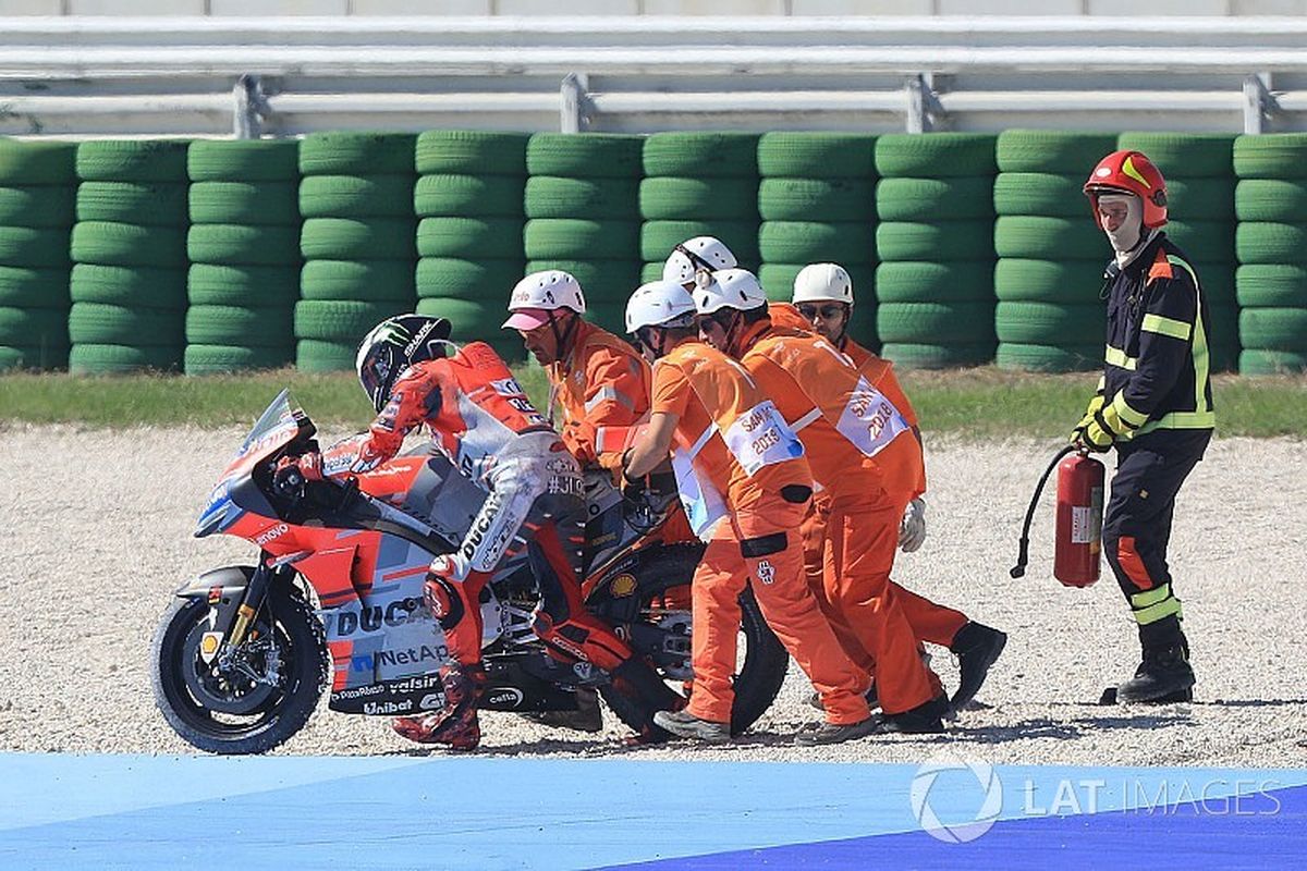Sejumlah marshall mencoba membantu pebalap Ducati Jorge Lorenzo untuk kembali ke lintasan setelah sebelumnya terjatuh dalam balap seri GP San Marino yang digelar di Sirkuit Misano, Minggu (9/9/2018). 