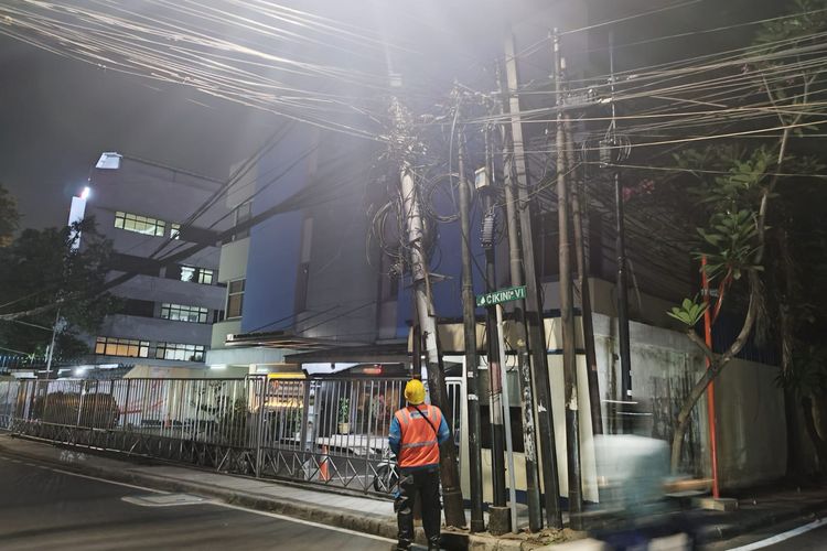 Petugas Pelayanan Teknisi PLN melakukan pengecekan tiang listrik yang miring di Jalan Cikini IV, Menteng, Jakarta Pusat, Kamis (7/9/2023). (KOMPAS.com/XENA OLIVIA)