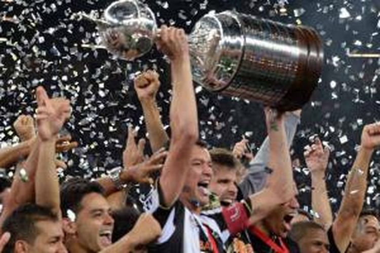 Kapten klub Brasil Atletico Mineiro, Rever, mengangkat trofi Copa Libertadores yang mereka menangi setelah di final leg kedua di Belo Horizonte, Brasil, Rabu (24/7/2013), mengalahkan wakil Paraguay, Olimpia. Pada leg kedua ini Atletico menang 2-0 sehingga agregat 2-2, yang diakhiri dengan adu penalti yang dimenangkan Atletico dengan 4-3.