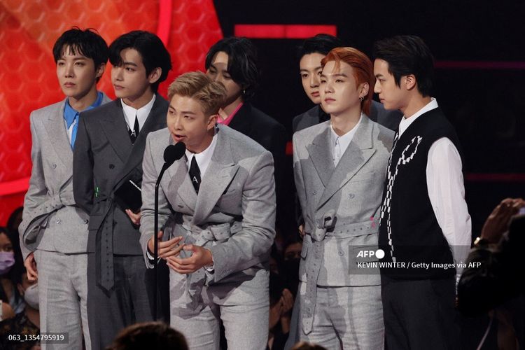 Para member BTS, (dari kiri) J-Hope, V, RM, Jimin, Suga, dan Jungkook, memberi sambutan atas penghargaan Artist of the Year di ajang American Music Awards 2021 yang digelar di Microsoft Theater, Los Angeles, pada Minggu (21/11/2021).   