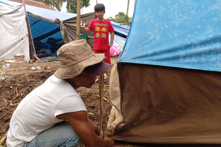 Seorang pengungsi di Kampung Warungbatu, Canjur, Jawa Barat, mendirikan tenda untuk hunian sementara pascagempa bumi yang mengguncang wilayah Cianjur dan sekitarnya.