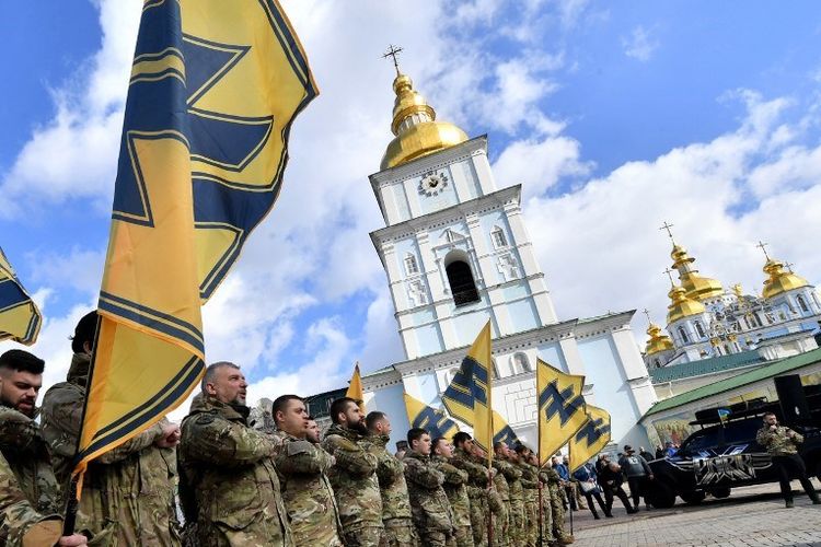 Veteran batalyon sukarelawan Azov, yang ambil bagian dalam perang dengan separatis yang didukung Rusia di Esat Ukraina, memberi hormat selama rapat umum yang disebut Tidak menyerah di Kiev pada 14 Maret 2020. 