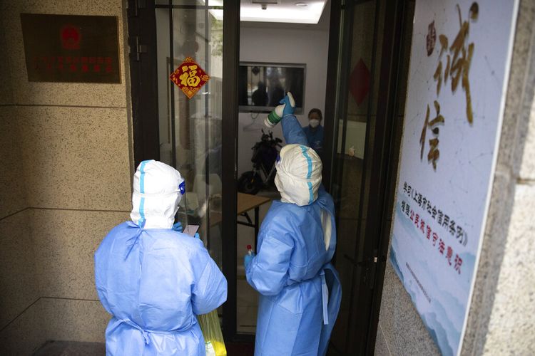 Dalam foto yang dirilis oleh Kantor Berita Xinhua China ini, petugas medis menyemprotkan disinfektan setelah mengambil sampel untuk tes COVID-19 di sebuah gedung di Shanghai, China, Sabtu, 16 April 2022.
