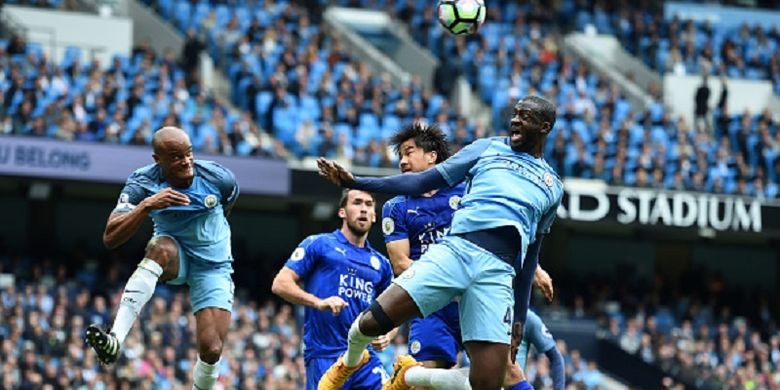Striker Leicester City, Shinji Okazaki, mencoba memenangi duel udara menghadapi dua pemain Manchester City, Vincent Kompany dan Yaya Toure, dalam pertandingan Premier League di Stadion Etihad, Sabtu (13/5/2017). 