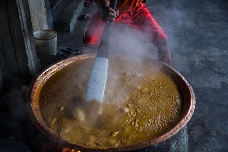 Pekerja mengaduk adonan dodol Betawi di rumah produksi pondok dodol Sari Rasa Ibu Yuyun di kawasan Pasar Minggu, Jakarta Selatan, Rabu (28/4/2021). Produksi dodol Betawi mengalami peningkatan jelang perayaan hari raya Idul Fitri. Dodol tersebut dijual mulai Rp. 10.000 hingga Rp. 100.000 per buah.