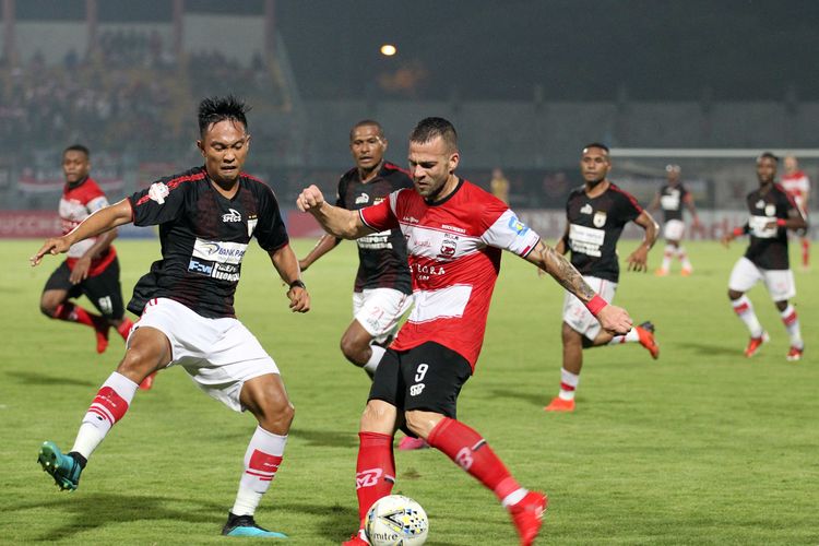 Pemain asing Madura United Aleksandar Rakic (kanan) di jaga kelat Pemain Persipura Jayapura M Tahir pada lanjutan Liga 1 2019 Pekan 26 yang berakhir dengan skor 0-2 di Stadion Gelora Bangkalan, Jawa Timur, Minggu (03/11/2019) malam.