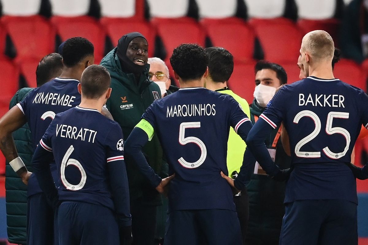 Penyerang Istanbul Basaksehir Demba Ba (kiri) berbicara dengan wasit setelah pertandingan ditangguhkan di tengah dugaan rasisme oleh salah satu ofisial pertandingan dalam pertandingan Grup H Liga Champions antara PSG vs Istanbul Basaksehir FK di Stadion Parc des Princes di Paris pada 8 Desember 2020.