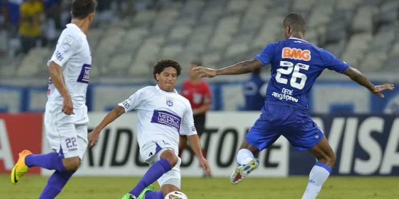 Bek Cruzeiro, Dede (kanan), mengawal penyerang Defensor Sporting, Felipe Gedoz (tengah), pada pertandingan Copa Libertadores, di Stadion Mineirao, Belo Horizonte, 20 Maret 2014.