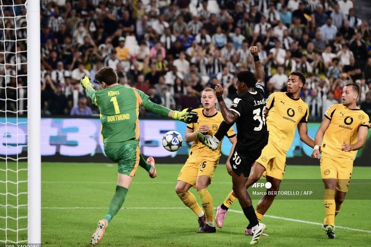 Jonathan David bertarung untuk meraih bola dengan kiper Gregor Kobel dalam pertandingan Liga Champions antara Juventus vs Borussia Dortmund di Stadion Allianz di Turin, Italia utara, pada 16 September 2025. (Foto oleh Marco BERTORELLO / AFP)