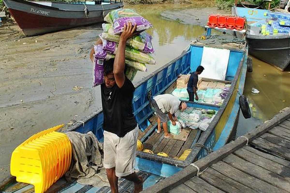 Suasana bongkar muatan perahu di Dermaga Lalo Salo, Pulau Sebatik, Nunukan, Kalimantan Utara, Rabu (21/12/2016). Sekitar 70 persen kebutuhan warga Sebatik didatangkan dari Tawau, Malaysia. Barang-barang ini masuk secara ilegal, dan kondisi ini sudah berlangsung bertahun-tahun.