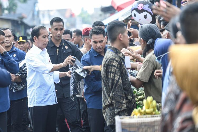 Presiden Joko Widodo (kiri) membagikan baju ke warga saat berkunjung ke Pasar Baru Karawang, Jawa Barat, Rabu (8/5/2024). Dalam kunjungannya ke pasar tersebut Presiden Joko Widodo mengecek harga bahan-bahan kebutuhan pokok seperti beras, cabai, bawang merah dan bawang putih. ANTARA FOTO/Hafidz Mubarak A/foc.