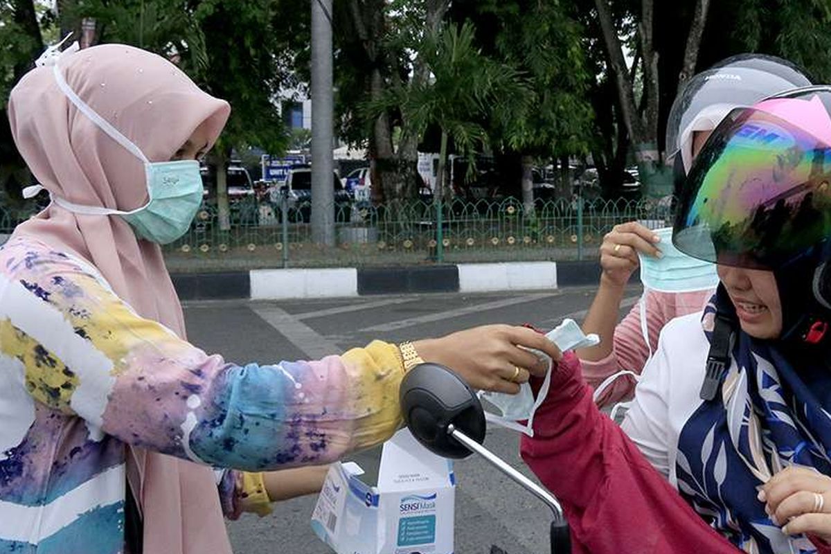 Relawan peduli kabut asap membagikan seribu masker kepada pengguna kendaraan di depan Masjid Raya Baiturrahman, Banda Aceh, Senin (23/9/2019). Berdasarkan data yang dirilis Badan Penanggulangan Bencana Aceh (BPBA) saat ini sembilan kabupaten di Aceh mengalami kondisi paparan kabut asap yang mulai parah, bahkan jarak pandang di dua kabupaten yang berada di perbatasan Sumut yaitu Kota Langsa dan Aceh Tamiang hanya berkisar 100-300 meter.