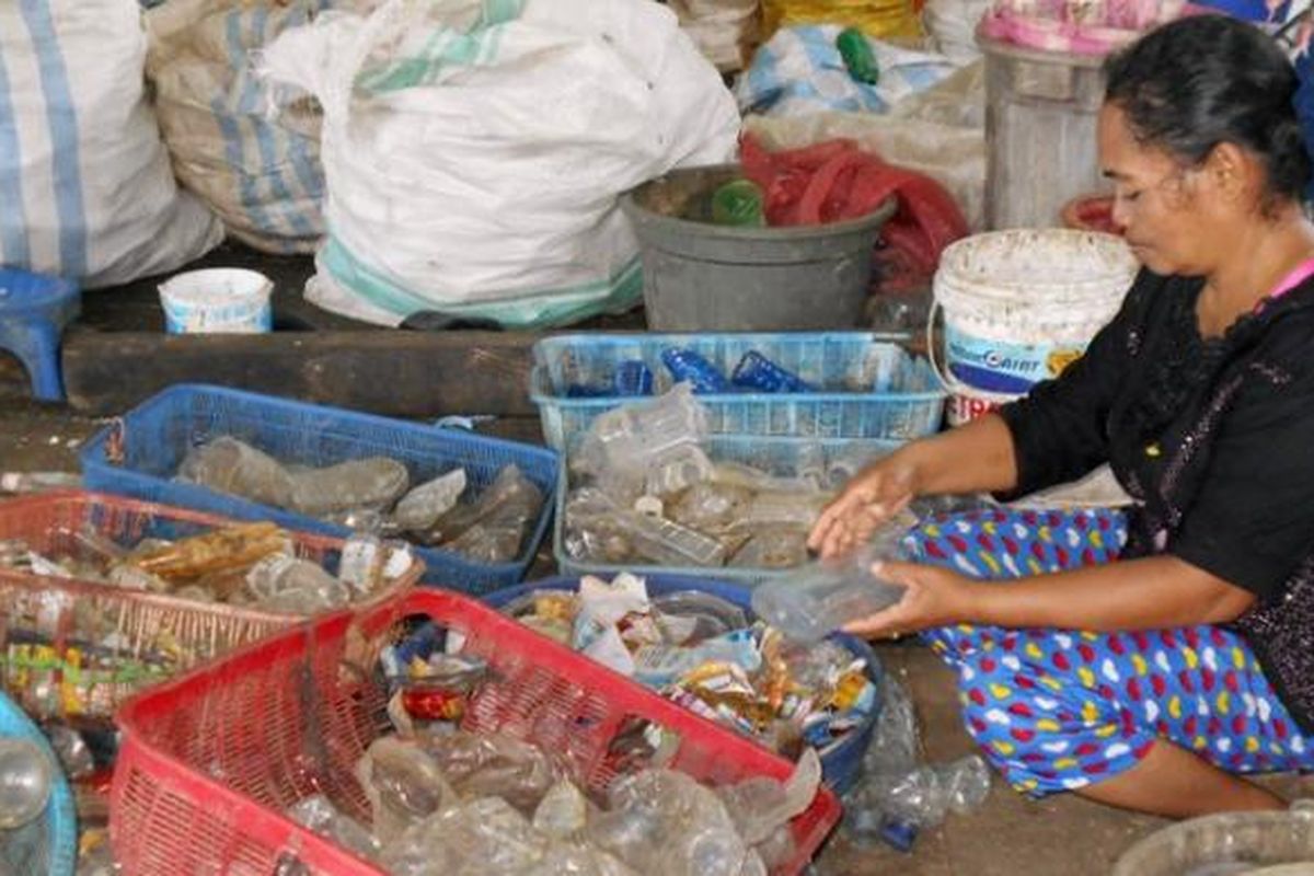 Buruh Di Tempat Daur Ulang Sampah Plastik, Hanasiah (46), sedang memilah-milah sampah plastik. Walau kerjanya sebagai buruh sampah, ia masih bisa membantu perekonomian keluarganya