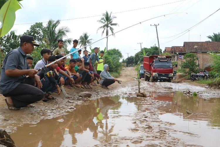 Warga Kecamatan Selagai Lingga, Lampung Tengah melakukan aksi protes dengan mancing di kubangan jalan utama Kampung Negeri Katon, Sabtu (23/4/2022). Warga protes lantaran jalan itu tak kunjung diperbaiki.