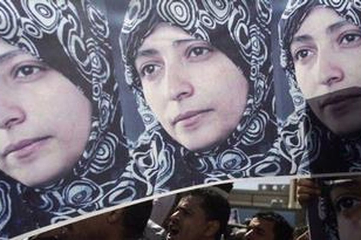 Para pengunjukrasa berteriak sambil mengusung poster aktivis Tawakul Karman di depan kantor Kejaksaan Agung di Sanaa, ibu kota Yaman, 23 Januari 2011.  Karman ditangkap, diduga karena dia sebelumnya memimpin pawai mahasiswa menuntut mundur Presiden Yaman.