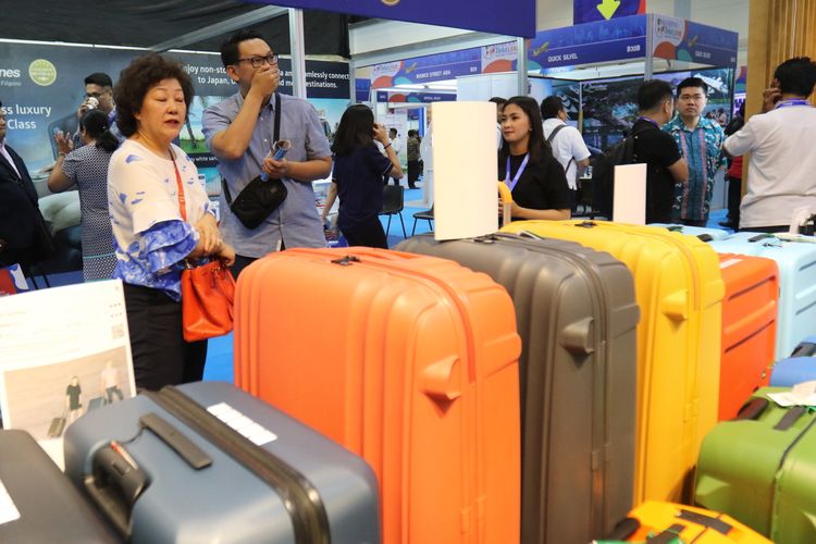 Pengunjung melihat koper di Kompas Travel Fair 2019, di Jakarta Convention Center, Jumat (20/9/2019). Pameran pariwisata yang berlangsung hingga 22 September 2019 ini diadakan serentak di tiga kota besar lainnya, yaitu Surabaya, Medan, dan Makassar.