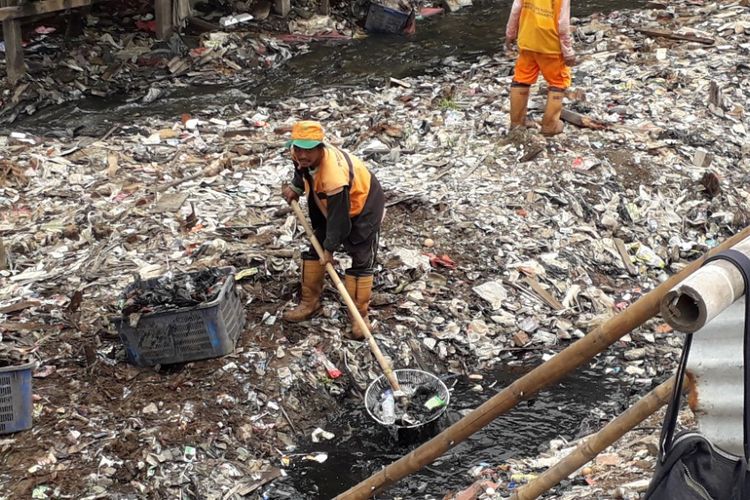 Petugas UPK Badan Air membersihkan sampah yang berada di Kali Gendong, Penjaringan, Senin (3/12/2018).